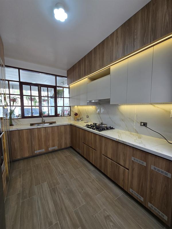 Cocina en U en tono madera con luz bajo muebles